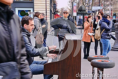 A talented homeless musician plays the piano in the street to earn some money