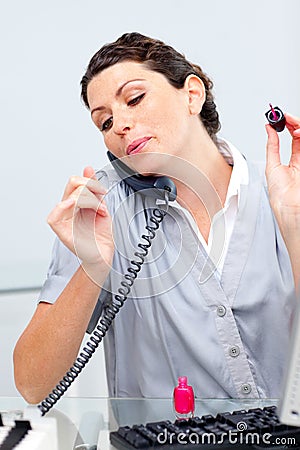 Talkative woman on phone painting her nails