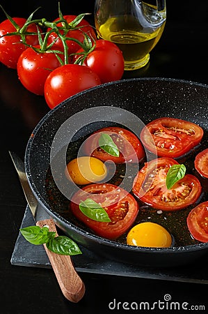 Tasty breakfast : fried eggs with tomatoes, cooking