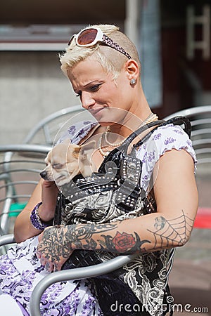 Tattooed woman with a dog in the handbag
