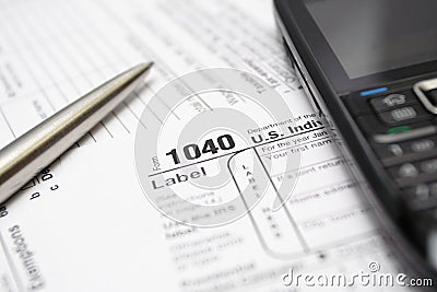 Tax forms, cell phone and pen