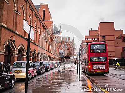 Taxis and bus on rainy street outside St Pancras Station, Bloomsbury, London