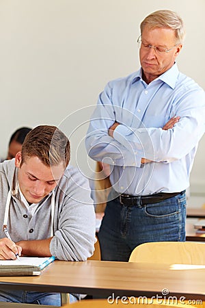 Teacher checking students at test