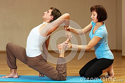 Teacher helping with yoga pose