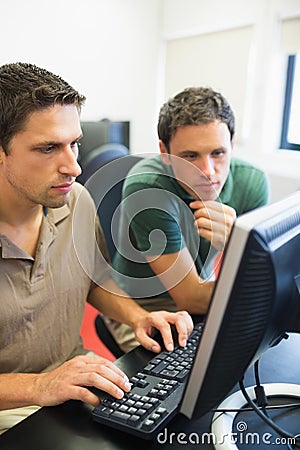 Teacher and mature student in computer room