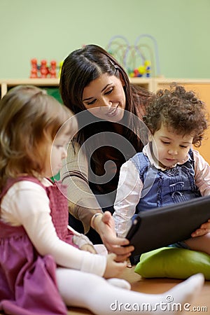 Teacher reading fairy tale to children at school