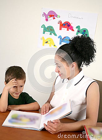 A teacher reads a book with her preschool student