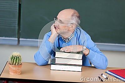 Teacher sitting thinking at his desk