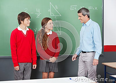 Teacher And Teenage Students Looking At Each Other