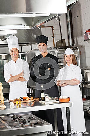 Team Of Confident Chefs In Industrial Kitchen