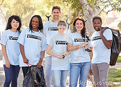 Team Of Volunteers Picking Up Litter In Suburban Street