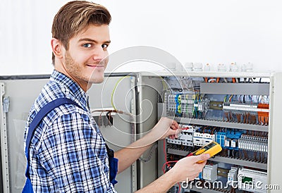 Technician examining fusebox with insulation resistance tester