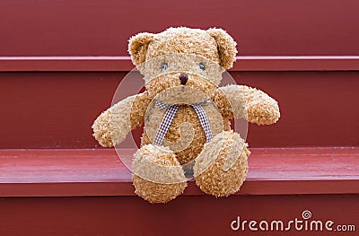 TEDDY BEAR brown color sitting on red staircase