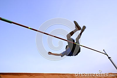 Teen clearing high jump bar