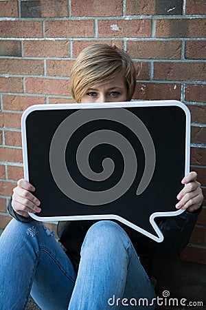 Teen girl holds black sign