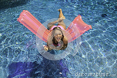 Teen girl in pink bikini on a float