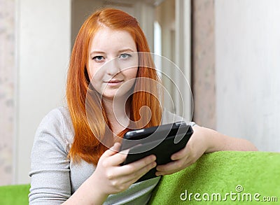 Teen girl reads e-reader or tablet computer