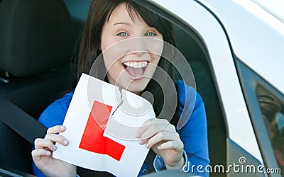 Teen girl sitting in her car tearing a L-sign