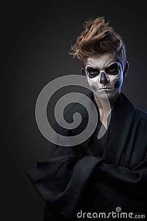 Teen with make-up of the skull in black cape