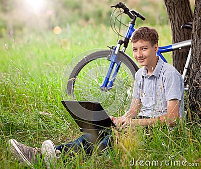 Teen in park with new laptop