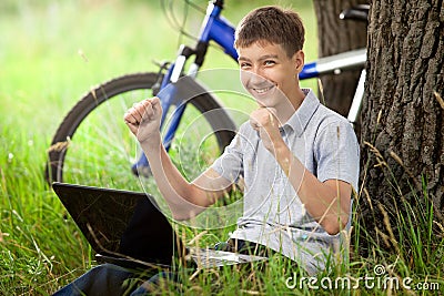 Teen in park with new laptop