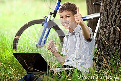 Teen in park with new laptop