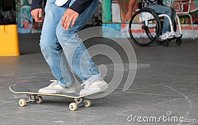 Teen skateboarder on skate board with disabled man