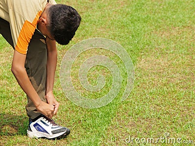 Teen tying his shoe