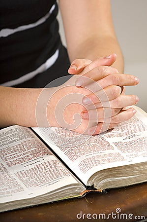 Teen woman praying over Bible