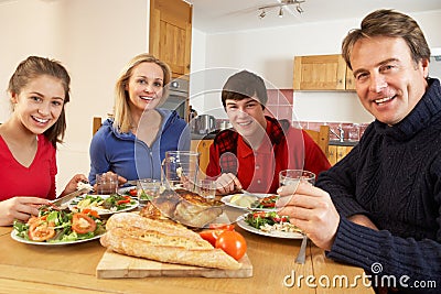 Teenage Family Eating Lunch Together In Kitchen