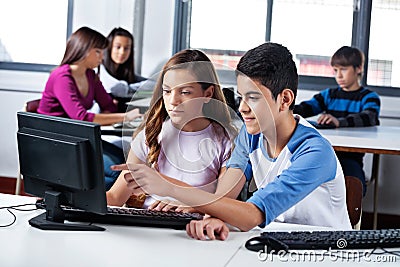 Teenage Friends Using Computer In Lab