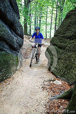 Teenage girl biking on forest trails