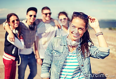 Teenage girl with headphones and friends outside