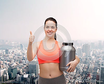 Teenage girl with jar of protein showing thumbs up