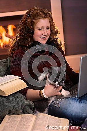 Teenage girl learning at home with cat