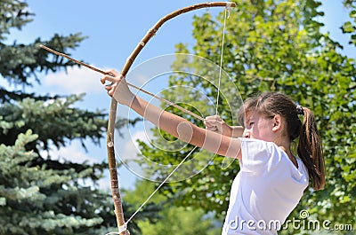 Teenage girl taking aim with a bow and arrow