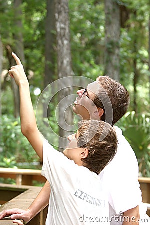 Teenager boy and his father hiking in summer park