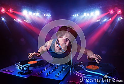 Teenager dj mixing records in front of a crowd on stage