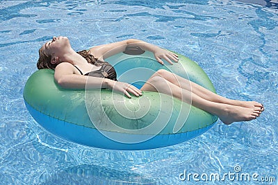 Teenager floating on float in pool