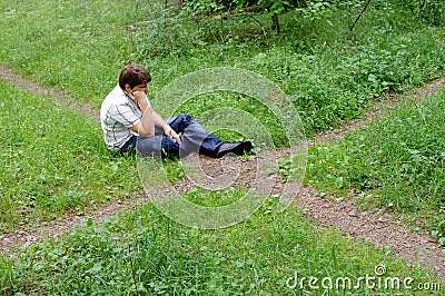Teenager in forest by crossroad choose the path
