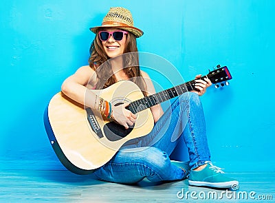 Teenager girl guitar play sitting on a floor.