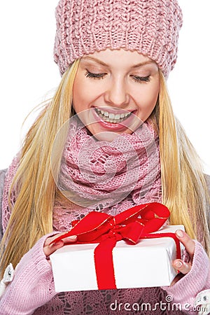 Teenager girl in winter hat and scarf with presenting box