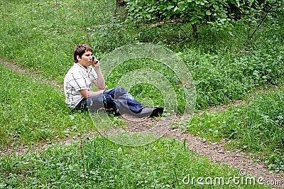 Teenager on phone in forest crossroad choose path