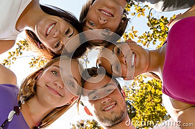Teens in a circle smiling in park