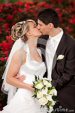 Tender wedding kiss red roses