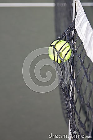 Tennis ball hitting the net on a court