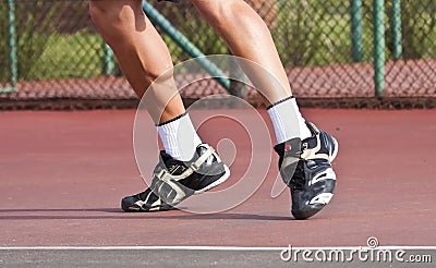 Tennis player legs and feet on court