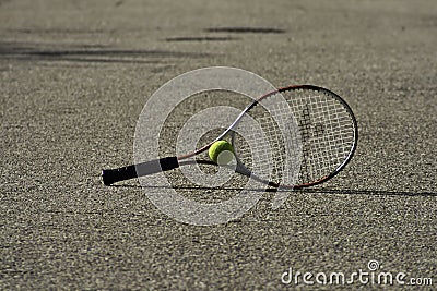 Tennis racket and ball on the ground