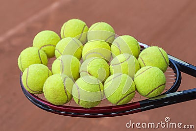 Tennis racket and balls on the clay court