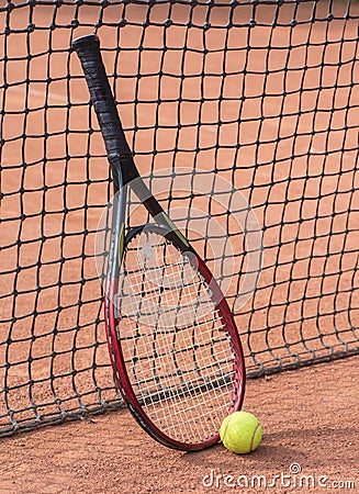 Tennis racket and balls on the clay court